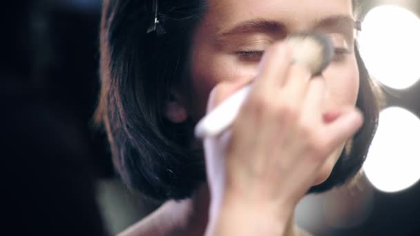 化粧品ブラシでメイクアップアーティストパウダーモデルの顔のトリミングビュー — ストック動画