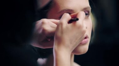 model alt göz kapağı siyah eyeliner uygulayarak sanatçı makyaj kırpılmış görünümü
