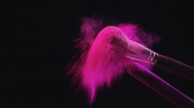 iki kozmetik fırçalar isabet ve pembe holi boya sıçramaları yapma yavaş hareket ateş
