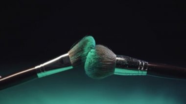 dokunmadan iki kozmetik fırçalar yavaş hareket ateş ve yeşil holi boya sıçrama yapma ve sonra toz yavaş yavaş aşağı düşen