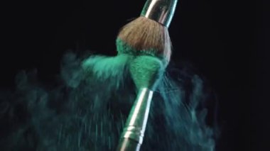 siyah arka plan üzerinde yeşil holi boya sıçramaları yapma kozmetik fırçalar yavaş hareket ateş