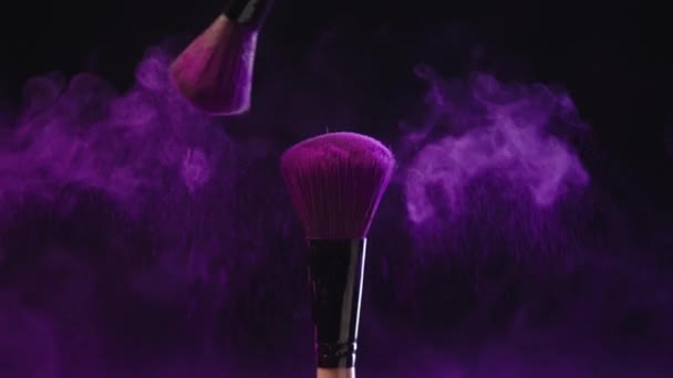 明るい紫色のホリ塗料をこすり 散乱する2つの化粧品ブラシのスローモーションシュート — ストック動画