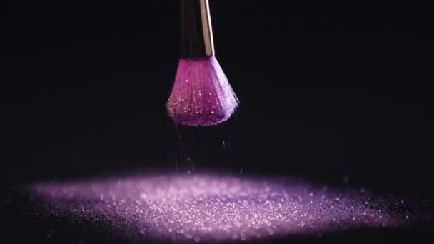 Lanzamiento Cámara Lenta Cepillo Cosmético Sacudiendo Dispersando Brillo Púrpura Brillante — Vídeos de Stock