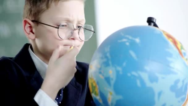 School Jongen Glazen Kijken Naar Globe Terwijl Het Houden Van — Stockvideo