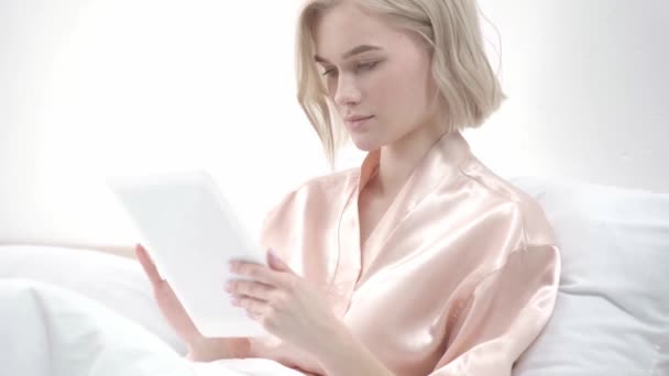 Щаслива Блондинка Використовує Цифровий Планшет Посміхається Ліжку — стокове відео
