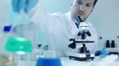 güzel doktora sıvı ile cam şişesi veren lateks eldiven yakışıklı bilim adamı