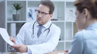 hastanede meslektaşı ile konuşurken kardiyogram tutan yakışıklı doktor