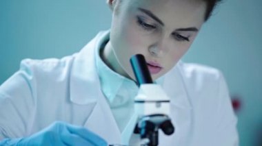 laboratuvarda çalışırken mikroskop görünümlü güzel, özenli bilim adamı