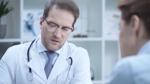 X線診断を見て 同僚と話すハンサムな医師の選択的な焦点 — ストック動画