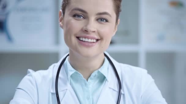 美しい若い医者が微笑み 病院でカメラを見ている — ストック動画