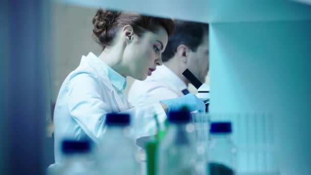 Foco Seletivo Cientista Bonito Olhando Microscópio Conversando Com Colega Laboratório — Vídeo de Stock