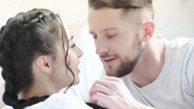 mutlu sakallı adam esmer kız ile konuşurken, kamera bakarak, dudakları dokunmadan ve evde gülümseyerek burun öpüşme 