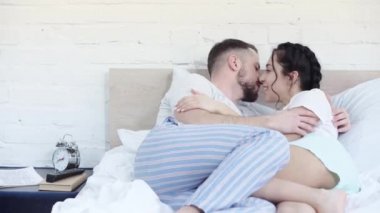 yatakta genç neşeli çift ve yatak odasında gülüyor 