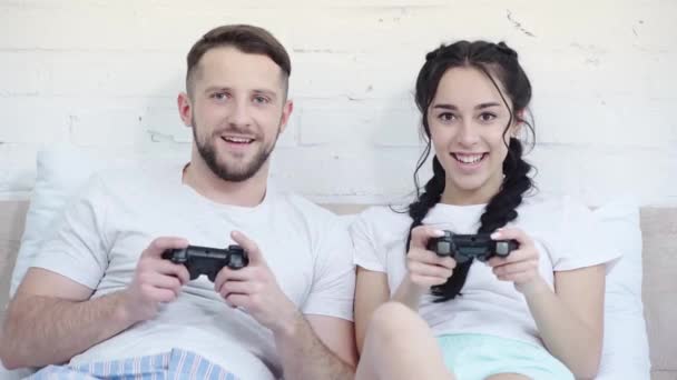 乌克兰 2019年3月21日 快乐的男人在玩视频游戏时打手势 在卧室里赢得接近迷人的女人 — 图库视频影像
