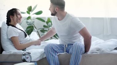 neşeli kadın kitap okurken erkek arkadaşı yüzük ile kutu tutarken, teklif yapma, parmak yüzük giyen ve yatak odasında mutlu kız arkadaşı sarılma 