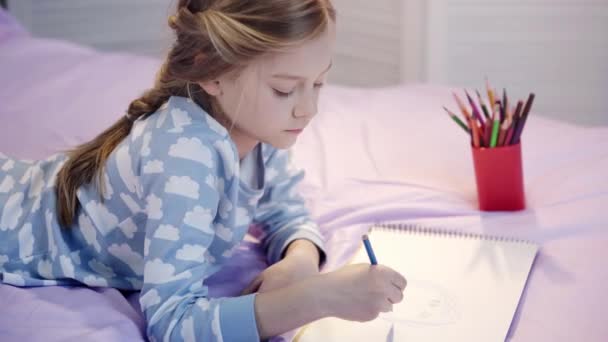 Carino Bambino Pigiama Sdraiato Sul Letto Disegno Con Matite Colore — Video Stock