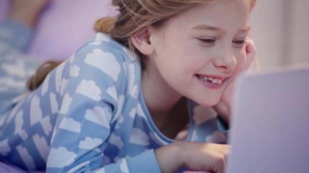 Підліток Піжамі Лежить Ліжку Використовуючи Ноутбук Підробку Обличчя Посмішкою — стокове відео