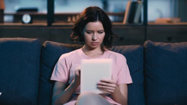 Mujer Joven Atenta Usando Tableta Digital Sonriendo Mientras Está Sentado — Vídeos de Stock