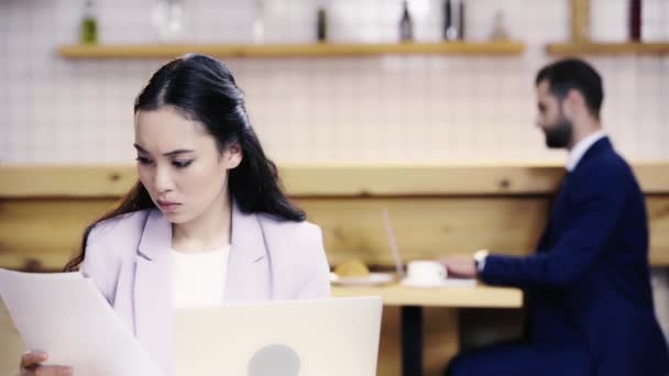 Mujer Negocios Seria Mirando Los Papeles Pantalla Del Ordenador Portátil — Vídeos de Stock