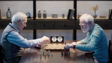 ahşap masada satranç tahtası üzerine rakamlar koyarak iki üst düzey erkek yan görünümü