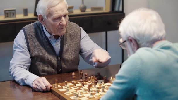 老人说话 而下棋与朋友和按下按钮的象棋时钟在表 — 图库视频影像