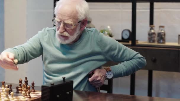 沉思胡子的老人在眼镜下棋与朋友和按下按钮在棋钟在表 — 图库视频影像