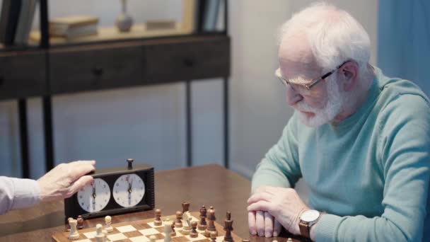 两个沉思的老人下棋的部分视图 手势和按下按钮在棋盘上 — 图库视频影像