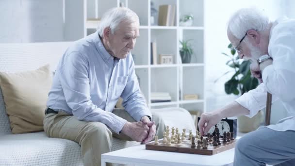 Zwei Nachdenkliche Senioren Beim Schachspielen Und Knopfdruck Auf Die Schachuhr — Stockvideo