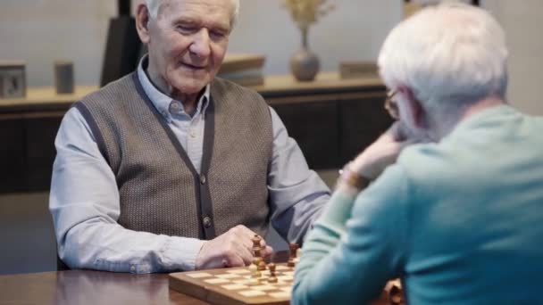 Senior Mann Weste Unterhält Sich Mit Gegner Beim Schach Wohnzimmer — Stockvideo