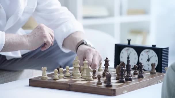 チェスをプレイし チェスクロック上のボタンを押すシニアの男のトリミングビュー — ストック動画