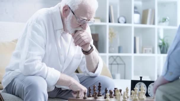 沉思胡子男子在眼镜下棋与对手和按下按钮的象棋时钟 — 图库视频影像