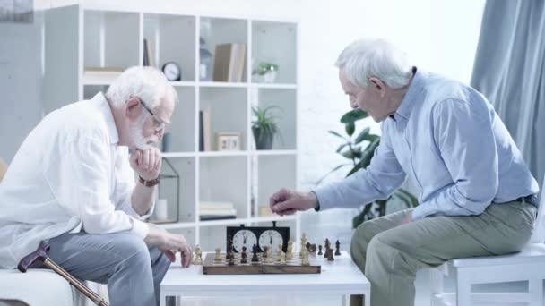 在客厅的象棋钟上 两位老人下棋和按下按钮的侧面视图 — 图库视频影像