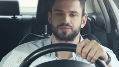 arabada kağıt tutarken direksiyon u tutan ve sallayarak yakışıklı adamın seçici odak 