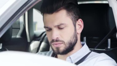 arabada oturan ve akıllı telefon kullanarak memnun olmayan adam seçici odak 