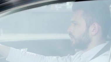 sakallı adamın yanında pencere açma seçici odak göz kırpma ve arabada otururken gülümseyerek ve kameraya bakarken 