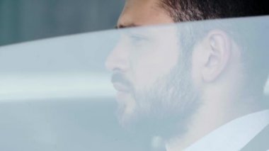 sakallı adamın yanında pencere açma yakın göz kırpma ve arabada otururken gülümseyerek ve kameraya bakarken 
