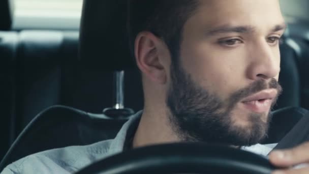 不快なあごひげの男の選択的な焦点は 時計を見て スマートフォンを取り 車の中で座っている間に時計を見て — ストック動画