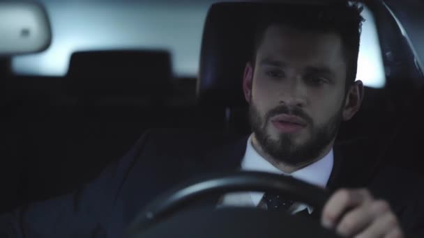 車を運転し スマートフォンを使用してハンサムな男の選択的な焦点 — ストック動画