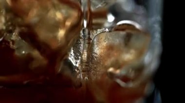 siyah izole dondurulmuş buz küpleri ile cam dökülen kola aromalı soda seçici odak 