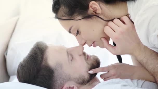 英俊的男人触摸黑发女友的脸 触摸鼻子和微笑在卧室 — 图库视频影像