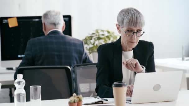 노트북을 사용하여 안경에 여자의 선택적 커피를 마시고 사무실에서 — 비디오