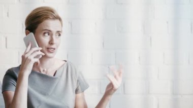 ofiste akıllı telefonda konuşurken mutlu kadın gesturing 