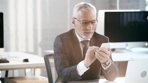 Hombre Barbudo Feliz Gafas Sonriendo Usando Teléfono Inteligente Oficina — Vídeos de Stock