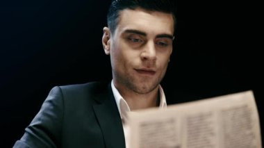 ciddi işadamı gazete okuma, viski içme ve siyah üzerinde izole yanıp sönen