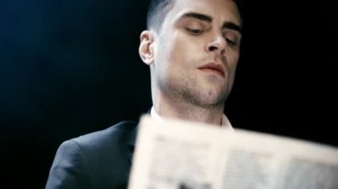 odaklı işadamı gazete okuma ve siyah üzerinde yanıp sönen