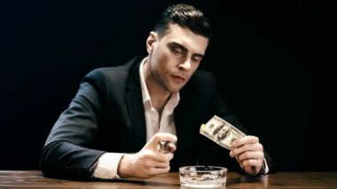iş işadamı siyah üzerinde izole ahşap masada küllük üzerinde hafif ve yanan dolar banknot