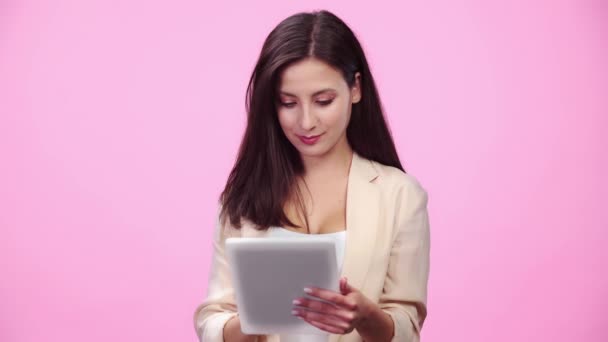 Menina Bonita Desgaste Formal Usando Tablet Digital Sorrindo Isolado Rosa — Vídeo de Stock