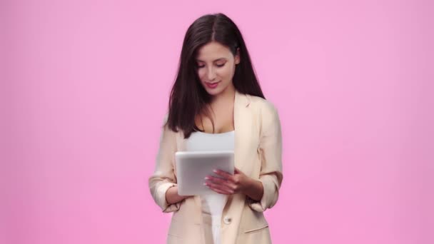 Menina Bonita Desgaste Formal Usando Tablet Digital Sorrindo Isolado Rosa — Vídeo de Stock