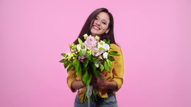 Hermosa Chica Olfateando Flores Mirando Cámara Sonriendo Aislado Rosa — Vídeos de Stock