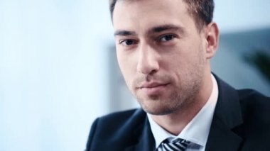 Kamera bakarken olumlu, yakışıklı işadamı gülümseyen yavaş hareket